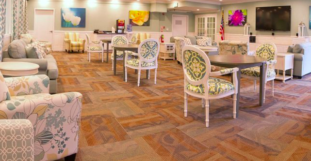 A cozy hotel lobby area with elegant furniture and decorative paintings on the walls.