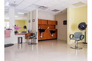 A well-organized hair salon interior with styling chairs and washing stations.