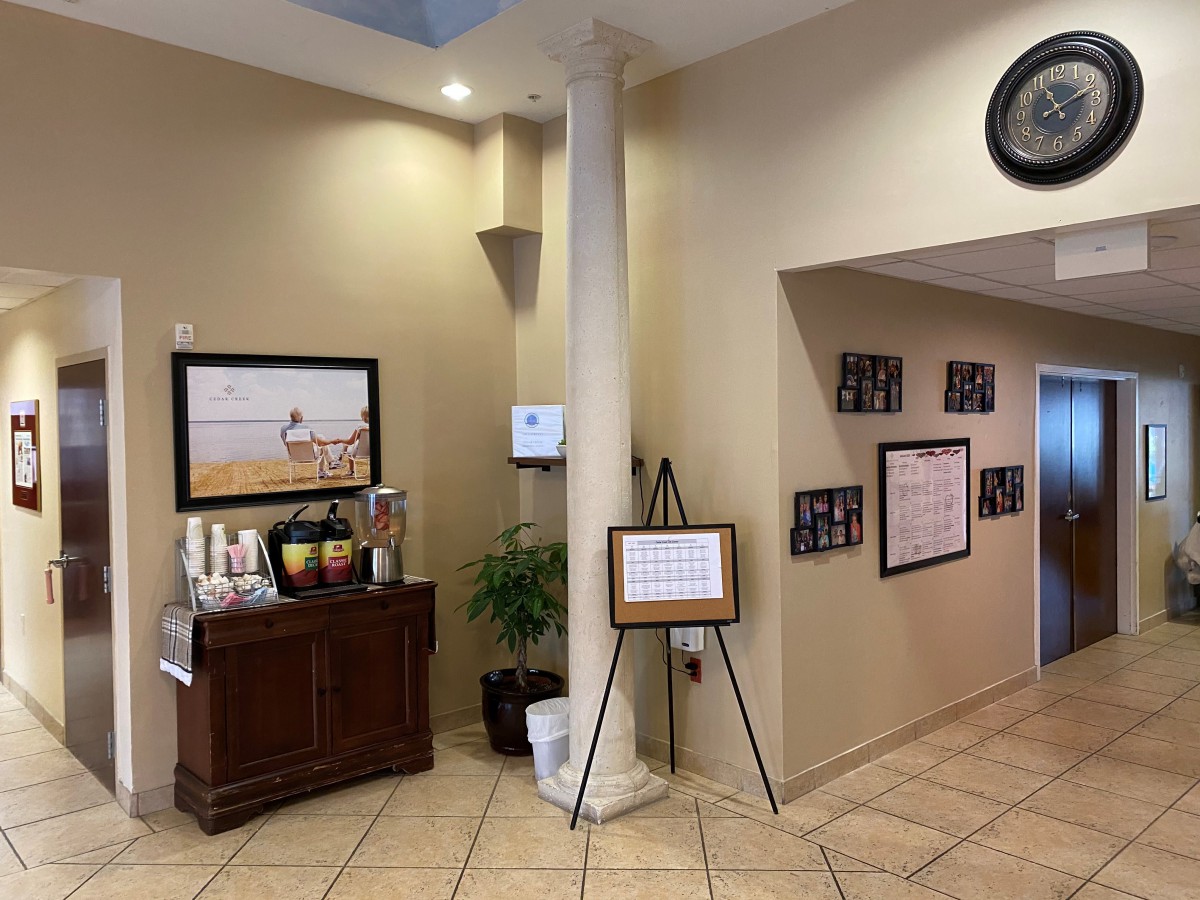 A neatly decorated lobby area featuring artwork, a small table with refreshments, and framed pictures on the wall.
