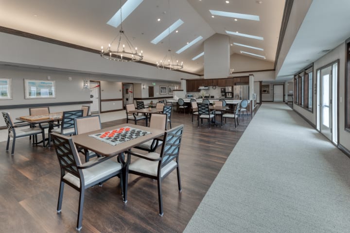 A spacious dining area with tables and chairs, well-lit by skylights and ceiling lights.