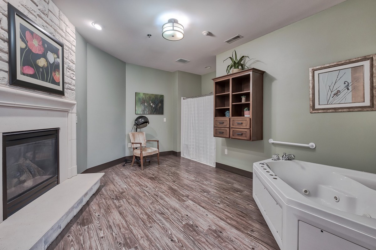 A modern bathroom with a bathtub, wooden flooring, and elegant decor.