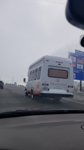 A view of a white bus driving on the highway.
