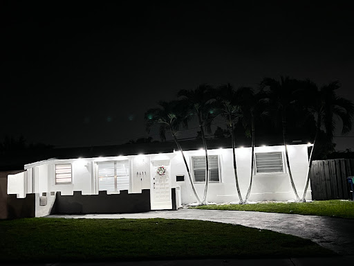 A well-lit house exterior captured during the night.