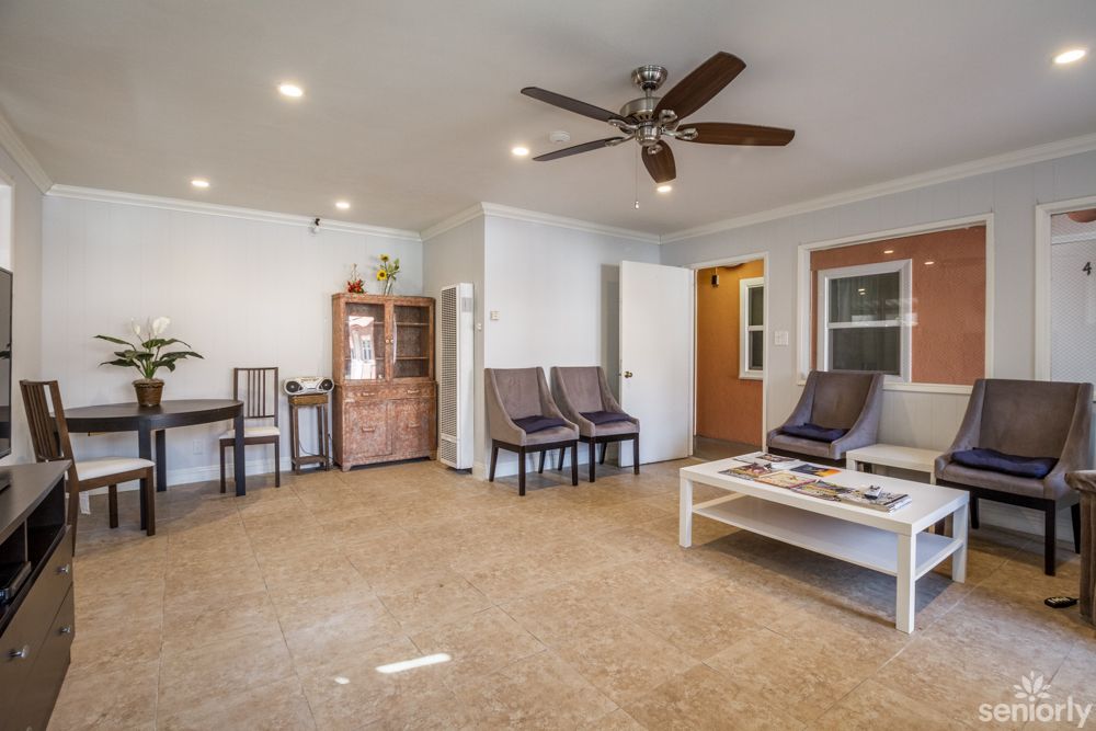 A spacious living room with modern furniture and a ceiling fan.