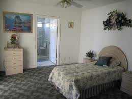 A cozy bedroom with a bed, carpeted floor, and attached bathroom.