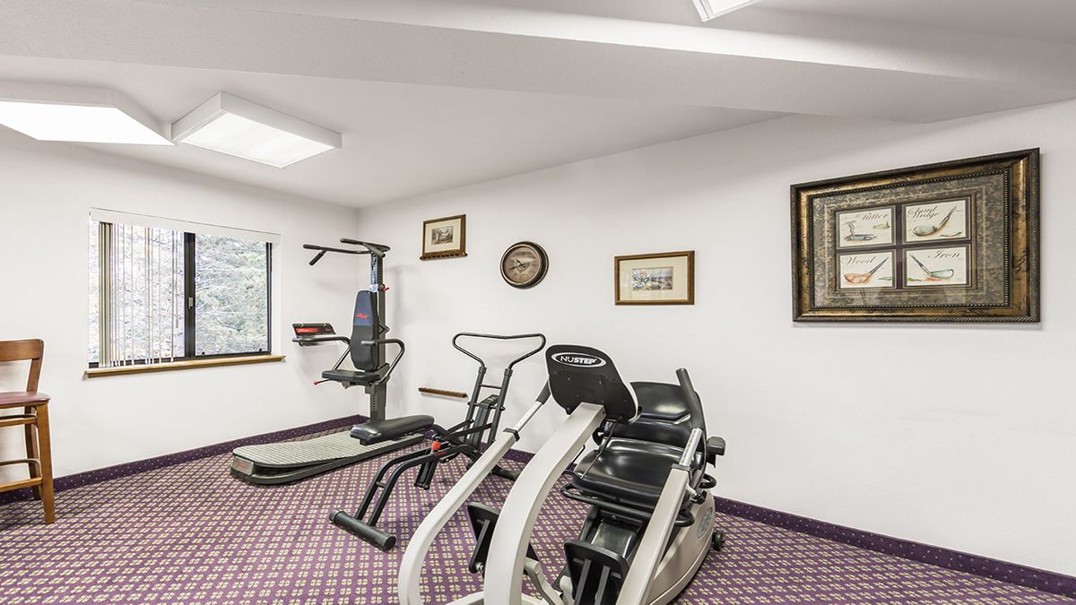 A small gym room with exercise equipment including a treadmill and stationary bike.