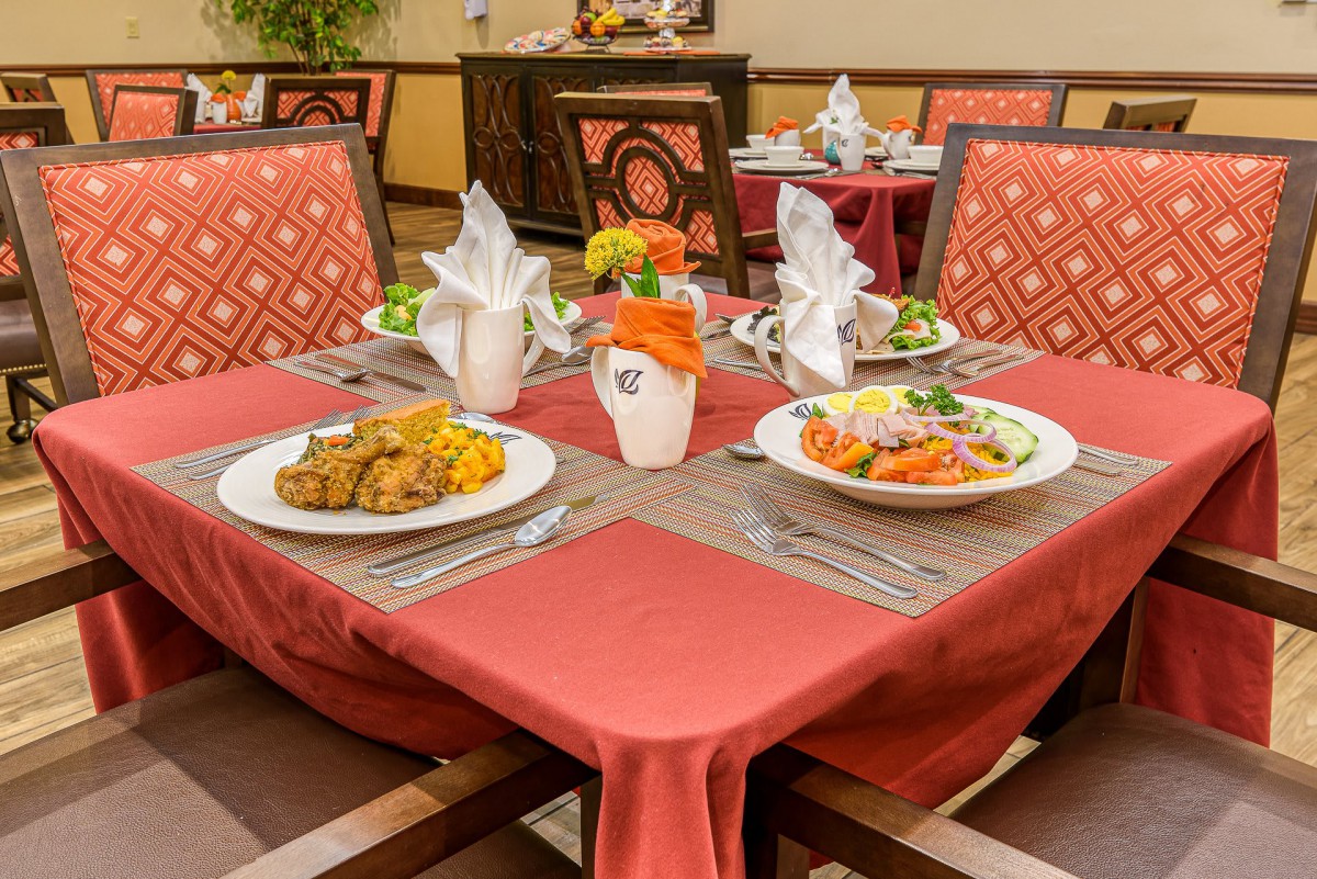 A beautifully set dining table with plates of food and neatly folded napkins at a restaurant.
