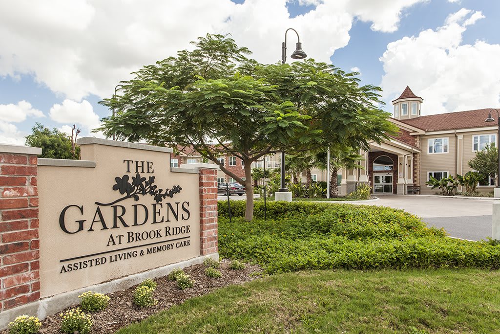 Entrance to The Gardens at Brook Ridge with a welcoming sign and lush greenery.