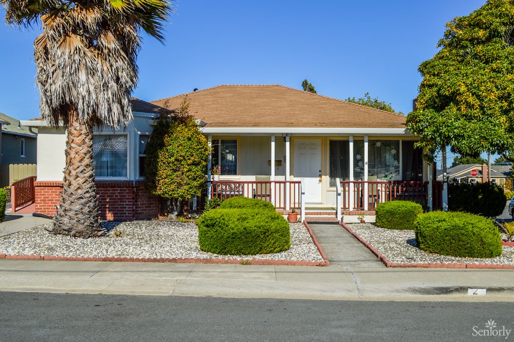 A suburban single-story house with a landscaped front yard and a small porch.