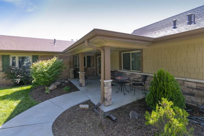 A cozy house with a covered porch and well-maintained garden.