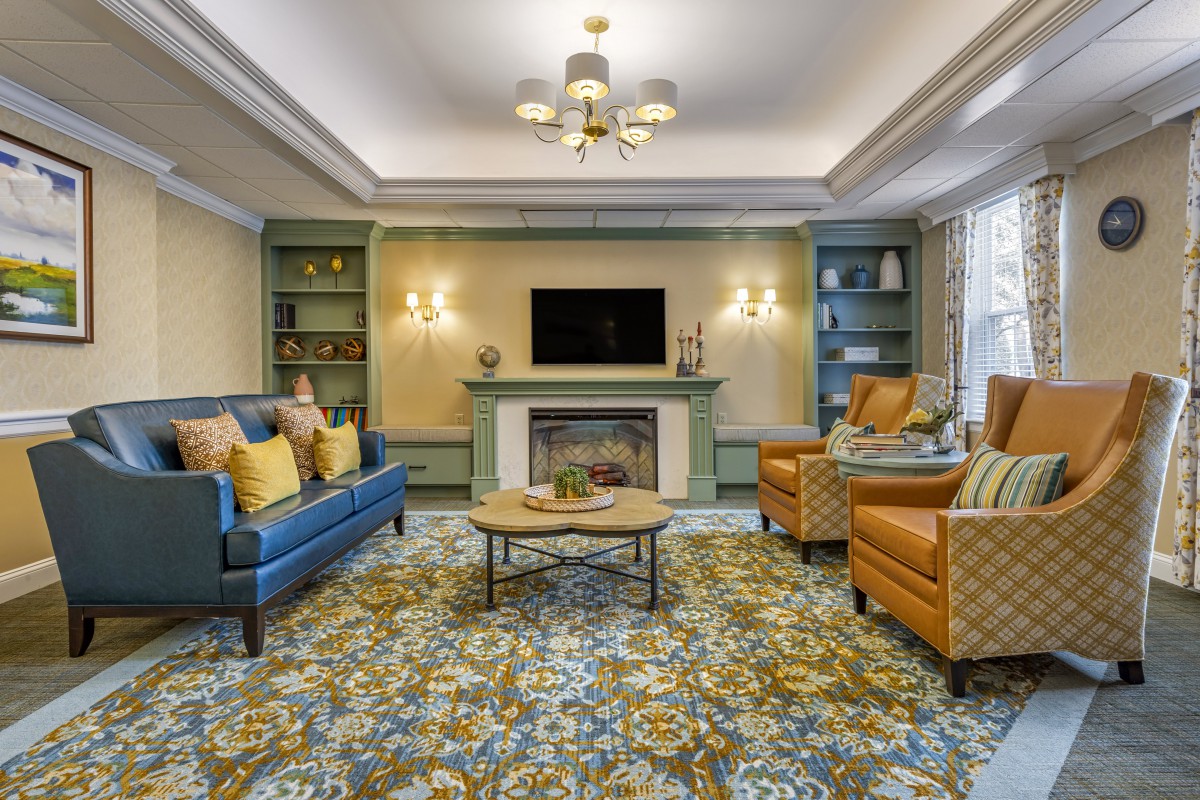 A well-decorated living room featuring comfortable seating, a fireplace, and modern lighting.