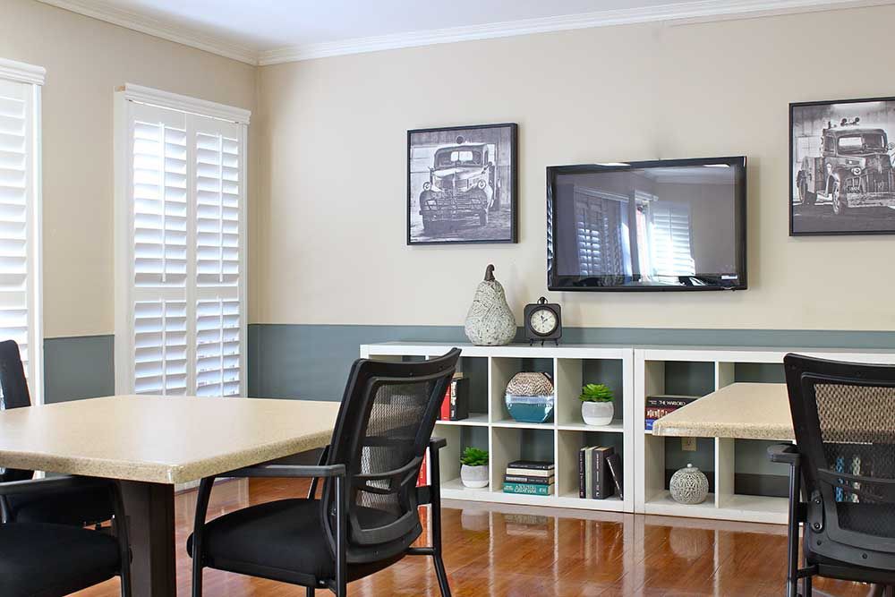 A modern office space with a desk, chair, and organized shelving.