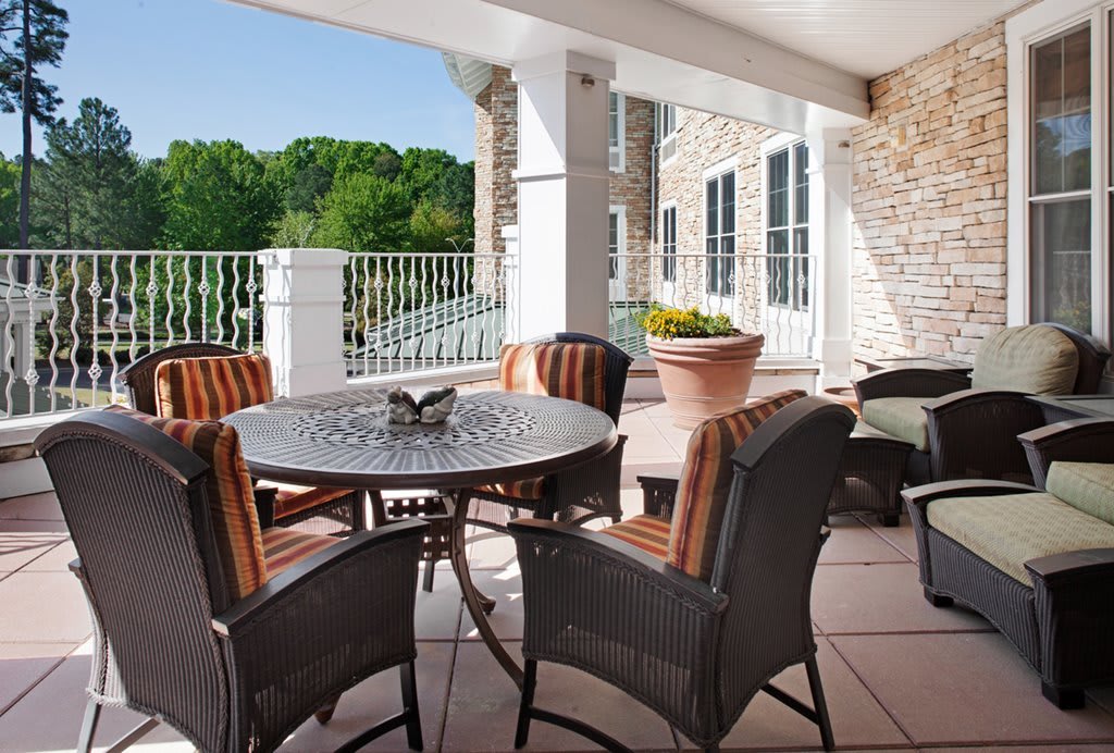 A cozy outdoor patio with a table and chairs overlooking a scenic nature view.