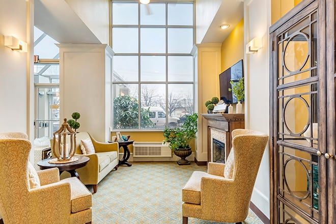 A cozy living room with large windows, comfortable seating, and natural light.