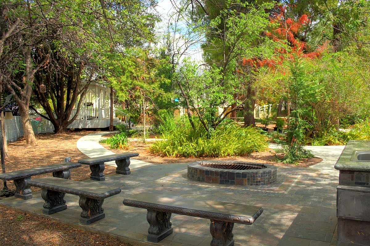 A tranquil park setting with stone benches and lush greenery.