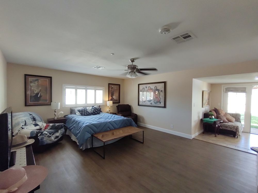A spacious bedroom with a large bed, hardwood floors, and cozy furnishings.
