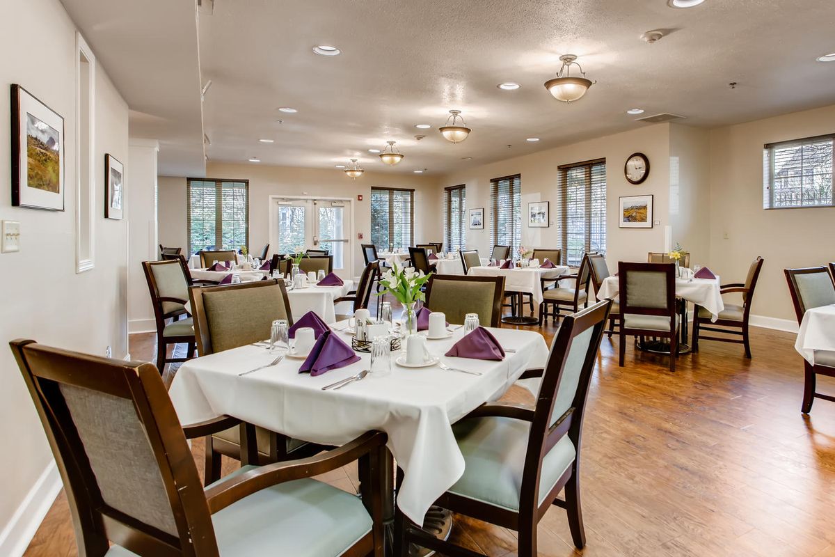 An elegantly arranged dining room with neatly set tables and chairs.