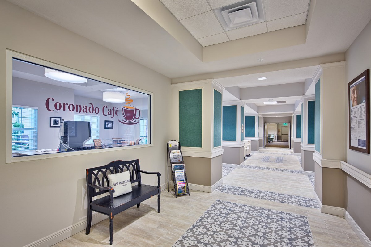 A modern office hallway featuring a bench and colorful decor.
