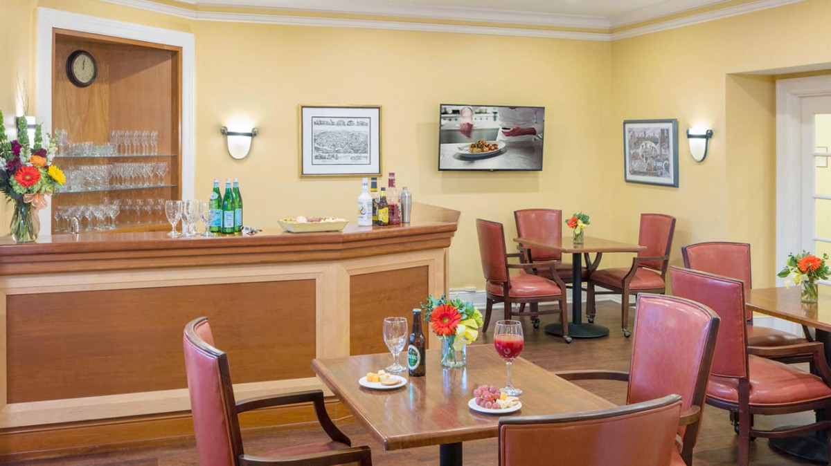 A cozy restaurant interior featuring a bar counter and dining tables.