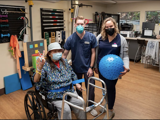 A dedicated healthcare team supporting a patient in a therapy session.