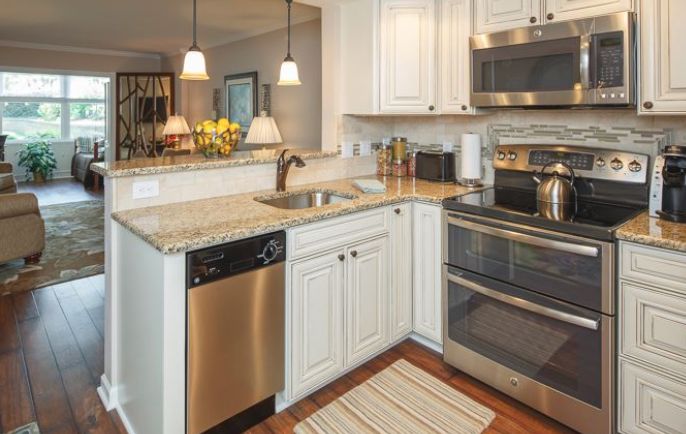 A modern kitchen with white cabinets and stainless steel appliances.