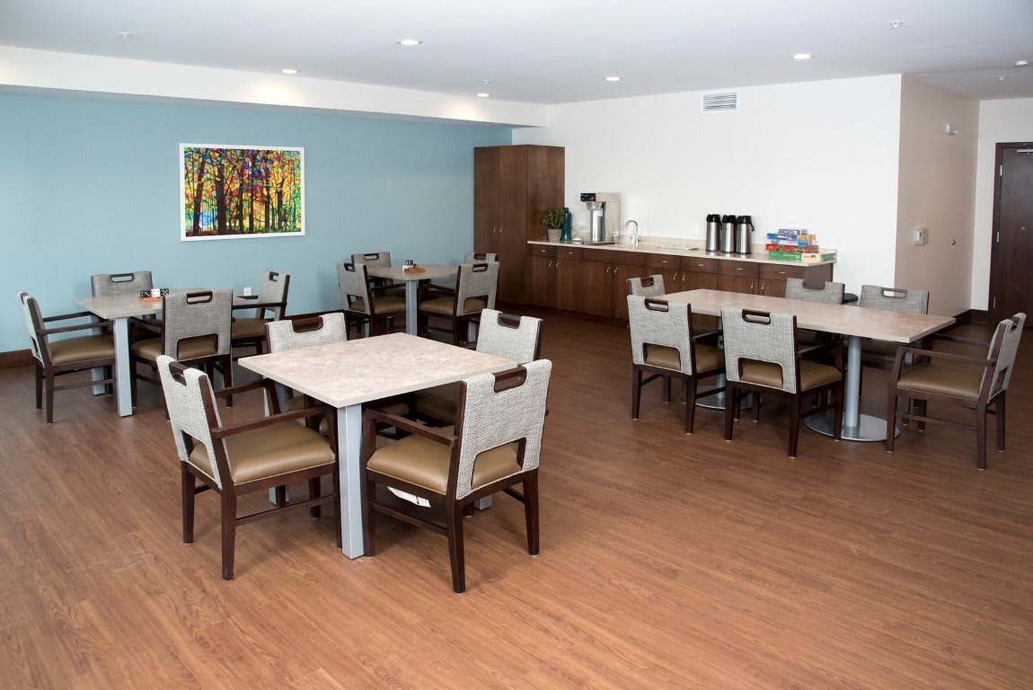 A modern dining area with tables, chairs, and a coffee station.