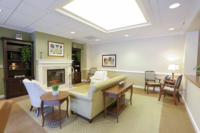 A cozy living room with elegant furnishings, including a fireplace, sofa, and coffee table.