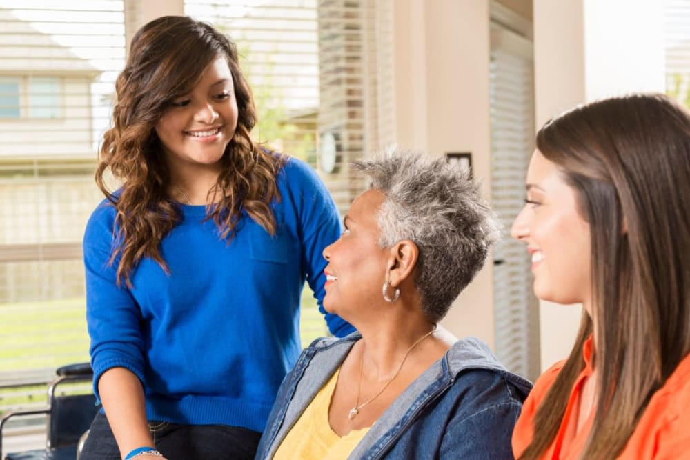 Three people engaging in a friendly conversation at home.