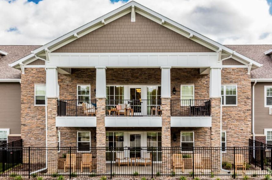 A two-story residential building with balconies and a brick facade.