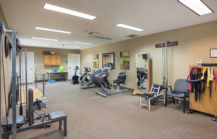 A fitness room equipped with various exercise machines and workout equipment.