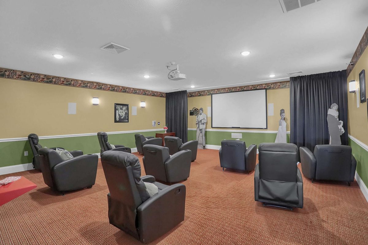 A cozy home theater room featuring several recliners arranged in front of a large projector screen.