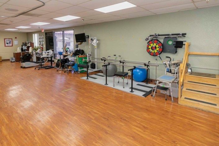 A rehabilitation room equipped with various exercise equipment for physical therapy.