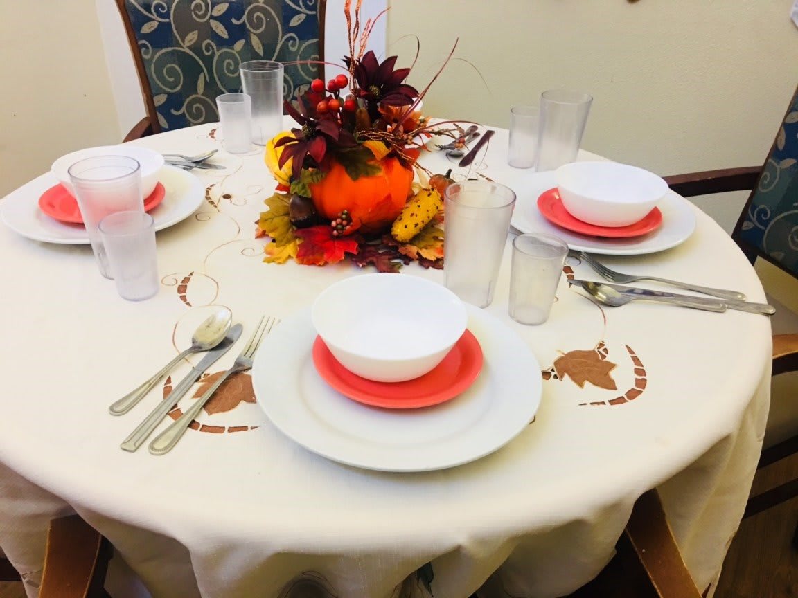 A festive autumn-themed table setting with a colorful centerpiece.