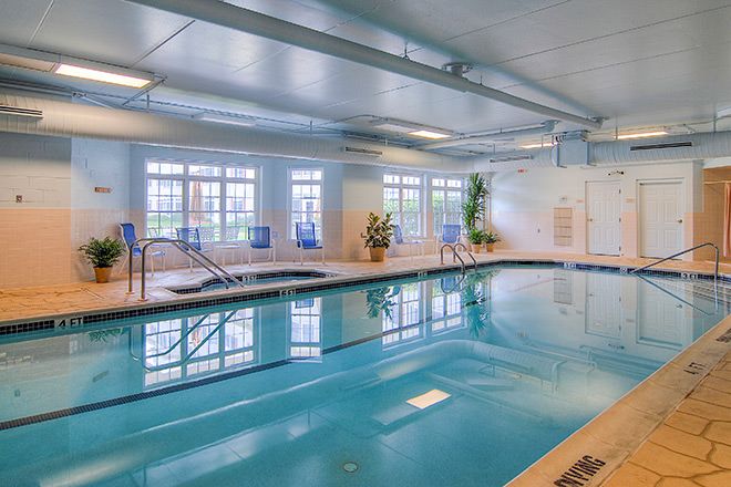 Indoor swimming pool with natural lighting and seating area.
