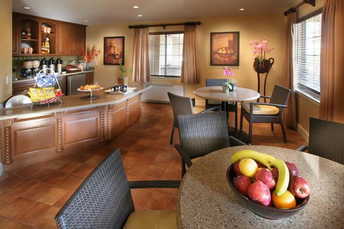 A modern kitchen and dining area featuring elegant furniture and a fruit bowl.