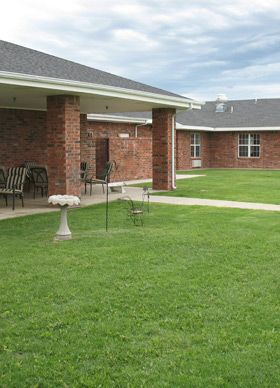 A serene courtyard with lush green grass surrounded by a brick building.