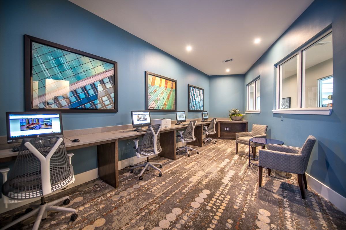 A modern office space with multiple workstations equipped with computers and stylish decor.
