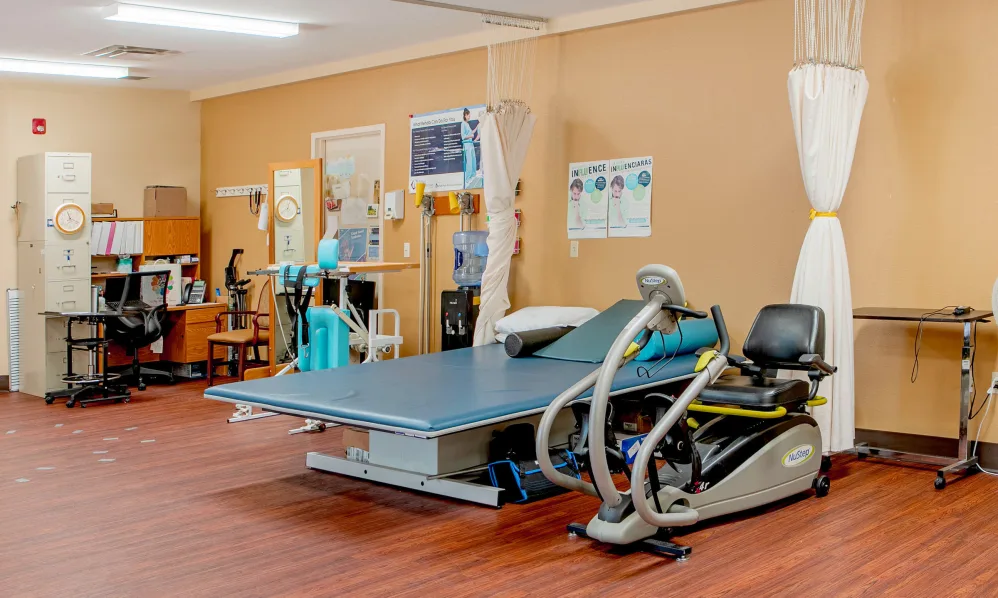 A rehabilitation center equipped with therapeutic exercise machines and treatment beds.