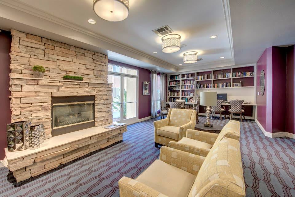 Cozy living room with a fireplace and a library section.