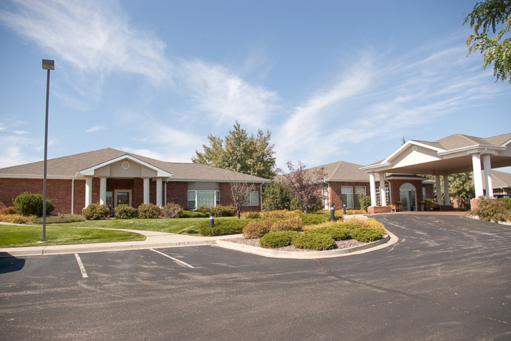 A suburban building with a landscaped driveway under a cloudy sky.