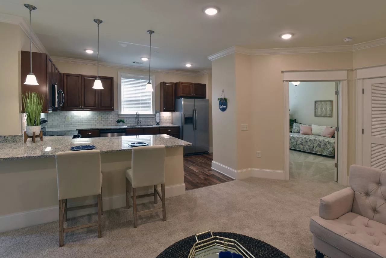 A modern open-concept kitchen and living area with contemporary furnishings and recessed lighting.