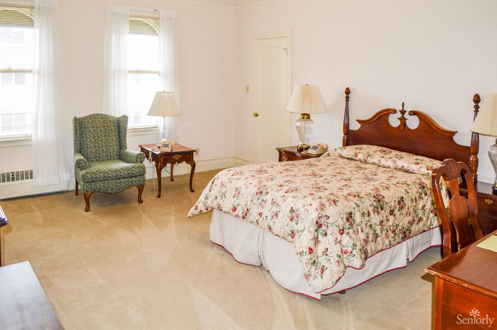 A classic-style bedroom with a floral bedspread and matching furniture.