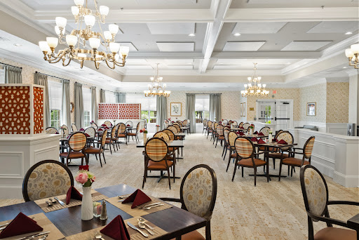 A spacious and elegantly designed dining area featuring classic furniture and stylish chandeliers.