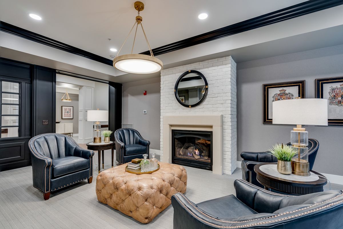 A cozy and stylish living room featuring a fireplace, leather seating, and modern decor.