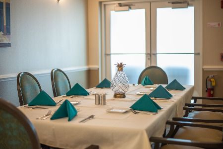 A neatly arranged dining room table with teal napkins and a decorative centerpiece.
