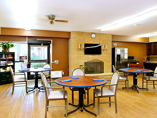 A cozy dining area featuring circular tables and comfortable seating, designed for community meals.