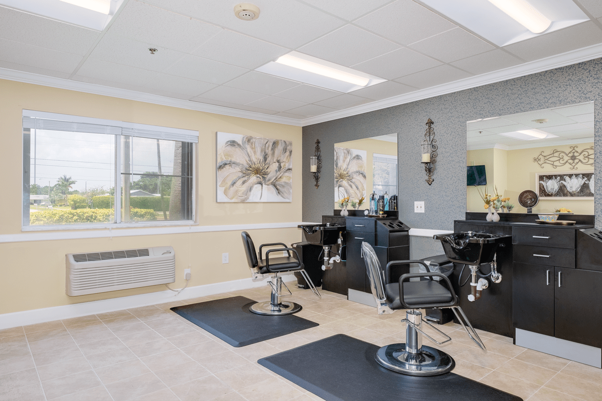 A modern hair salon interior with stylist chairs and mirrors, featuring decorative artwork on the walls.