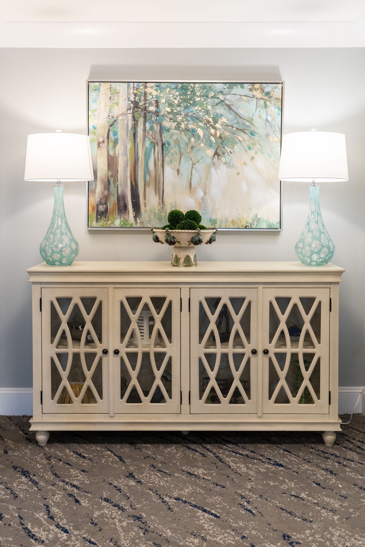 A stylish console table with decorative lamps, artwork, and plants enhancing the interior decor.