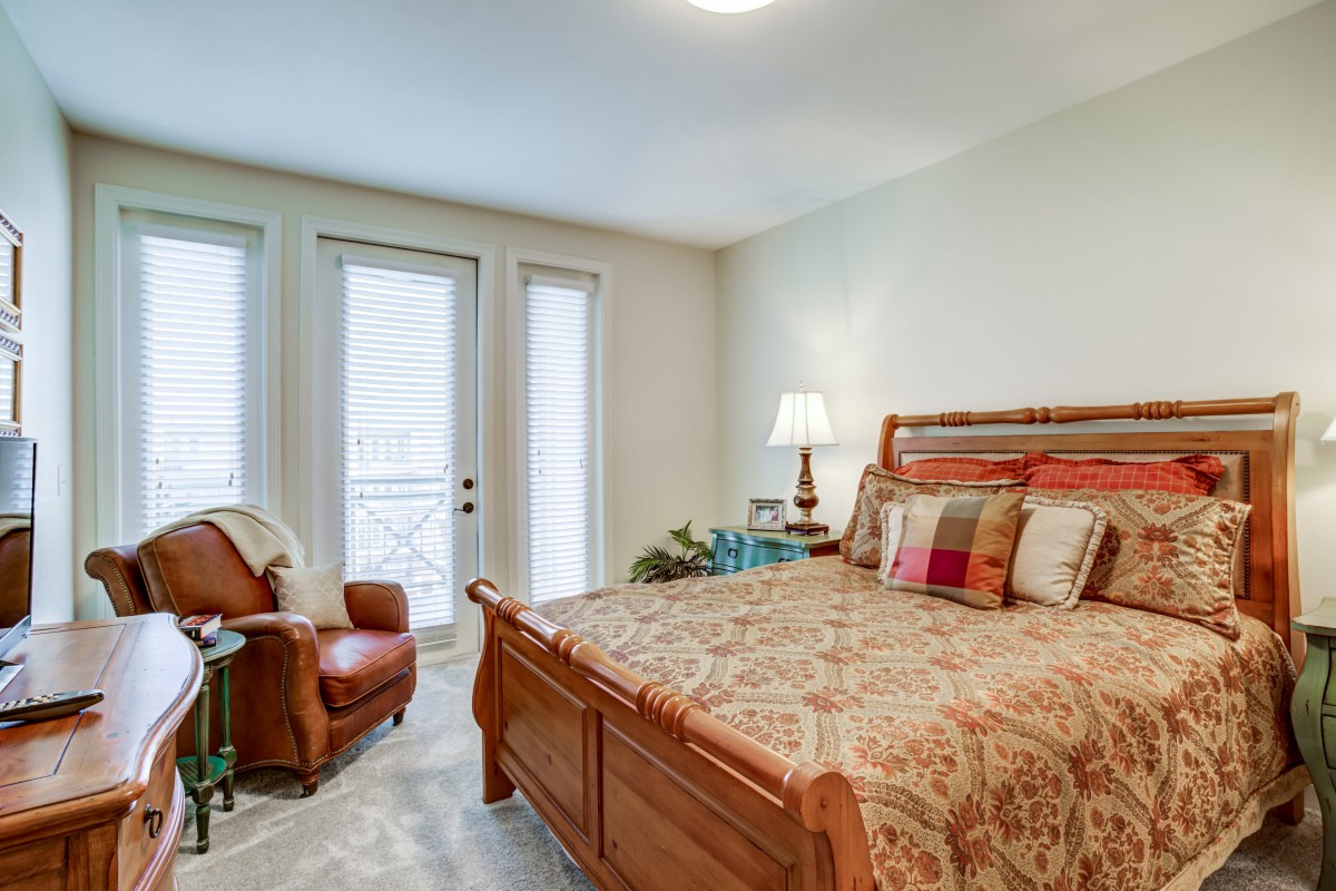 A cozy bedroom with classic wooden furniture and ample natural light.