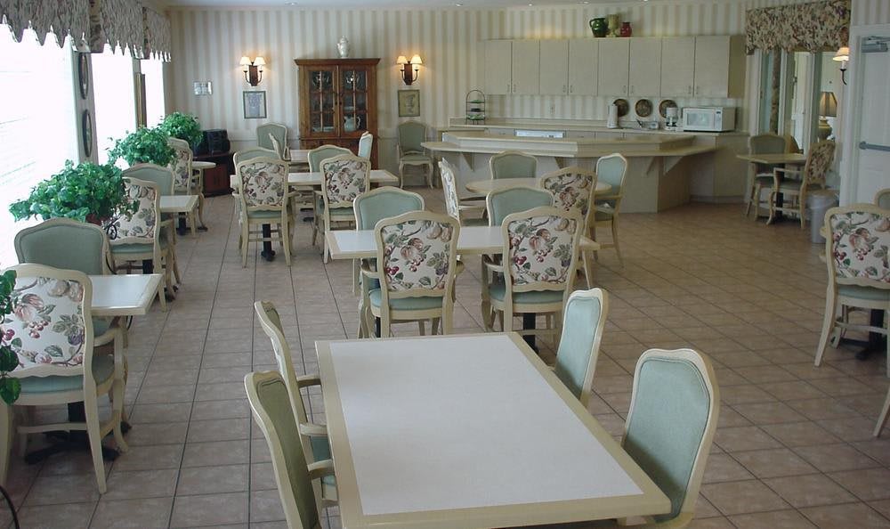 An empty dining room with multiple tables and chairs arranged neatly.